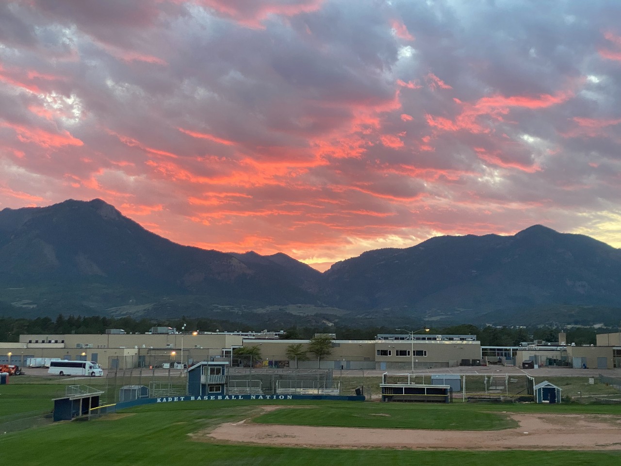 A view of the AAHS baseball field with a mountain sunset in the background.